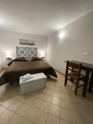 ein Schlafzimmer mit einem Bett, einem Tisch und einem Stuhl in der Unterkunft Normanni Central House in Palermo
