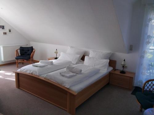 ein Schlafzimmer mit einem großen Bett mit weißer Bettwäsche und Kissen in der Unterkunft Gästehaus Helbighof in Neustadt an der Weinstraße