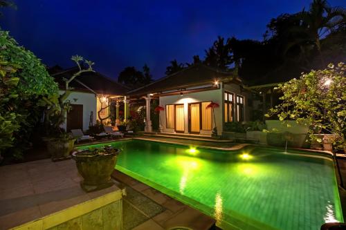 ein Pool im Hinterhof in der Nacht in der Unterkunft Padma Ubud Retreat in Ubud