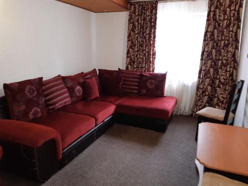 a living room with a red couch and a window at Ra in Bukovel