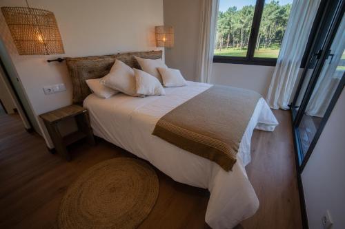 a bedroom with a large bed with a large window at Balarés Hotel da Natureza in Ponteceso