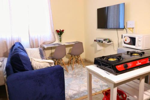 ein Wohnzimmer mit einem Herd und einem TV in der Unterkunft Lux Suites Mtwapa Studio Apartment-2 in Mtwapa