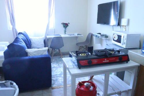 ein Wohnzimmer mit einem blauen Sofa und einem Tisch in der Unterkunft Lux Suites Mtwapa Studio Apartment-2 in Mtwapa