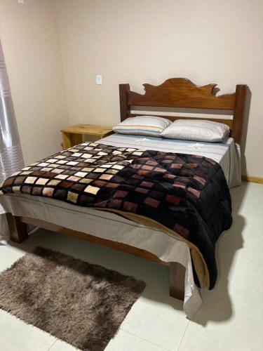 - un lit avec une tête de lit en bois dans une chambre dans l'établissement Casa Beira Rio, à Urubici