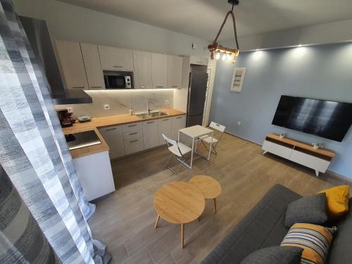 uma sala de estar com um sofá, uma mesa e uma cozinha em La Casita a brand new apartment in the center em Argostoli