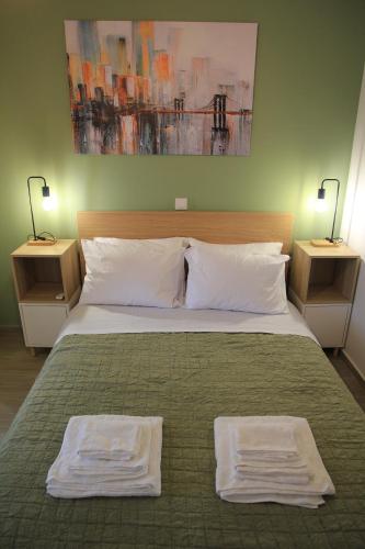 a bedroom with a bed with two towels on it at La Casita a brand new apartment in the center in Argostoli