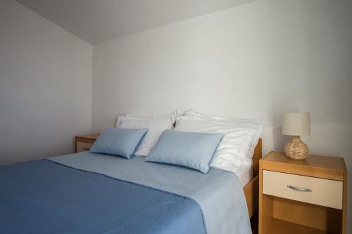 a bedroom with a bed with two blue pillows at Lemon tree in Podaca