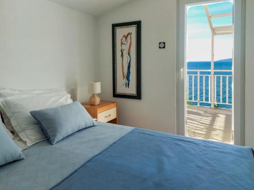 a bedroom with a blue bed and a balcony at Lemon tree in Podaca