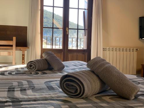 twee bedden met handdoeken bovenop in een slaapkamer bij Casa Taconera in Ansó