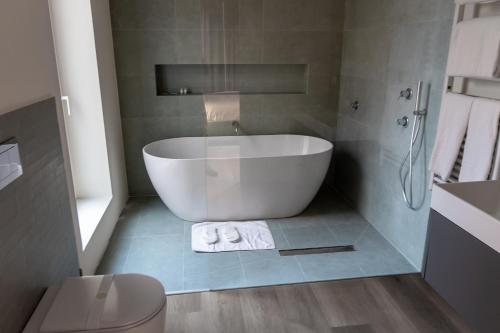 a bathroom with a white tub and a toilet at Pasubio Quattro BB in Catania