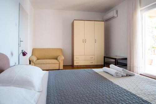 a bedroom with a bed and a chair and a window at Lemon tree in Podaca