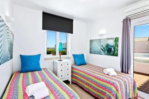 twee bedden in een kamer met twee ramen bij Villa Stefy by Bedzy in Galé