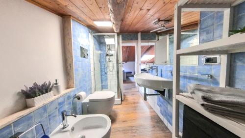 baño con paredes de azulejos azules y 2 lavabos en Due passi dal mare, en Montecorice