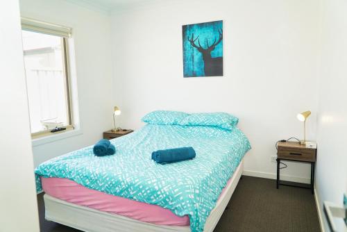 um quarto com uma cama com um edredão azul em Modern style unit 2 Deer Park em Deer Park