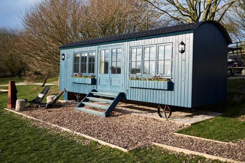 a blue tiny house sitting in a yard at Hog Deer Creek - At Port Lympne Reserve in Hythe