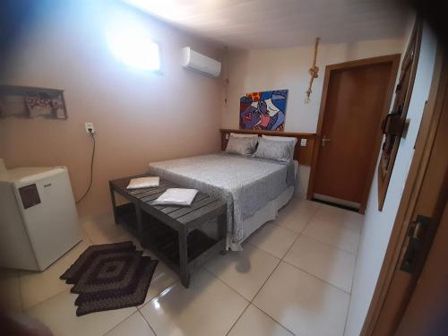 a small bedroom with a bed and a table at Suítes Pirenópolis Piri in Pirenópolis