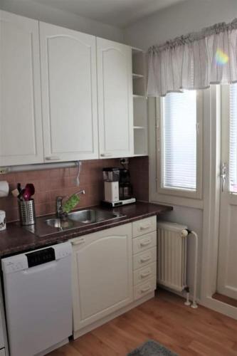 a kitchen with white cabinets and a sink at Studio middle of town centre. in Tornio