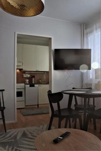 a living room with a table and a kitchen at Studio middle of town centre. in Tornio