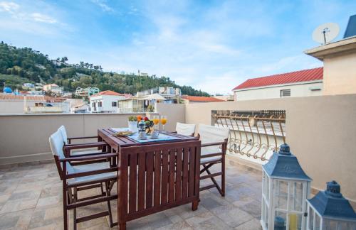 een patio met een tafel en stoelen op een balkon bij Victor Junior Suite in Zakynthos