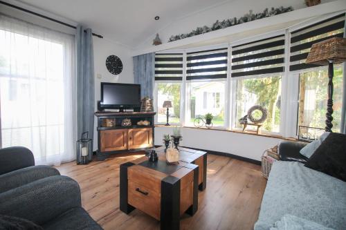 sala de estar con sofá y mesa de centro en Sfeervol chalet op de Veluwe en Putten