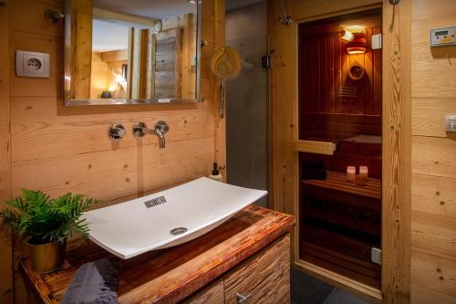 une salle de bain avec un lavabo et un miroir dans l'établissement Lodge le Chevreuil - OVO Network, au Grand-Bornand