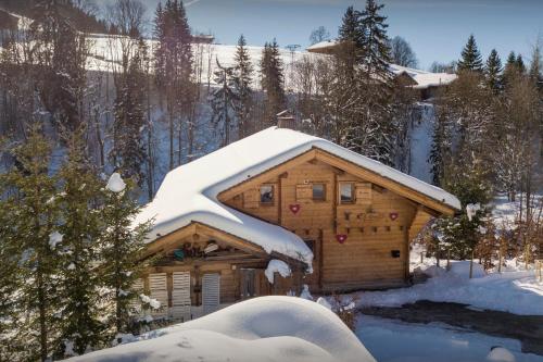 domek z bali i śniegiem na dachu w obiekcie Lodge le Chevreuil - OVO Network w mieście Le Grand-Bornand