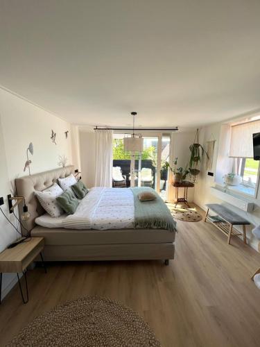 a bedroom with a large bed and a large window at By Mosk in Engelum