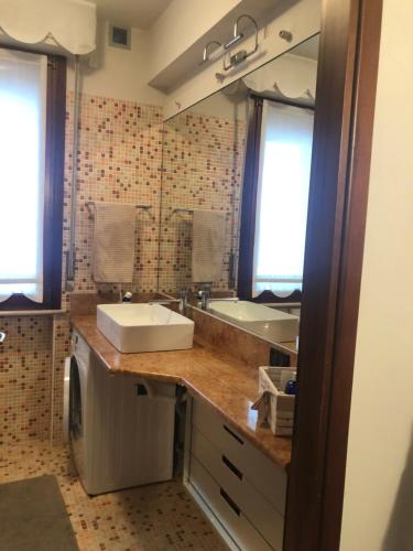 a bathroom with a sink and a tub and a mirror at Appartamento direttamente a lago in Sirmione