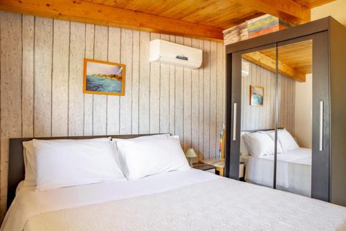 a bedroom with a white bed and a mirror at Villa Lucia in Ognina