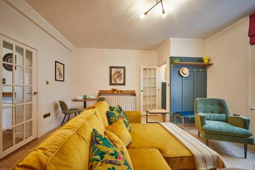 a living room with a yellow couch and chairs at The Jungle Nook; Romantic Haven in Berwick-Upon-Tweed