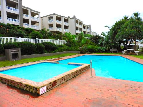 a large blue swimming pool in front of a building at Laguna la Crete 214 in Uvongo Beach