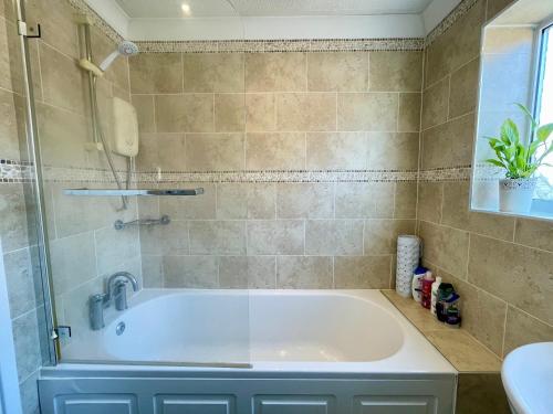 een badkamer met een bad en een douche bij Double Room in Cosy Quiet Home - House Shared with One Professional in Bristol