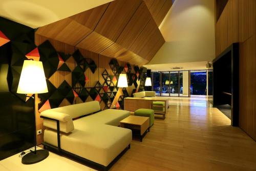 a living room with a couch and chairs and a lamp at Namin Dago Hotel in Bandung