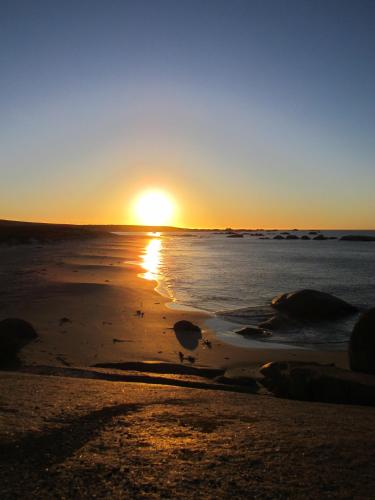 a sunset on the beach with the tide coming in at Nieuview Cottages 1 and 2 in Paternoster