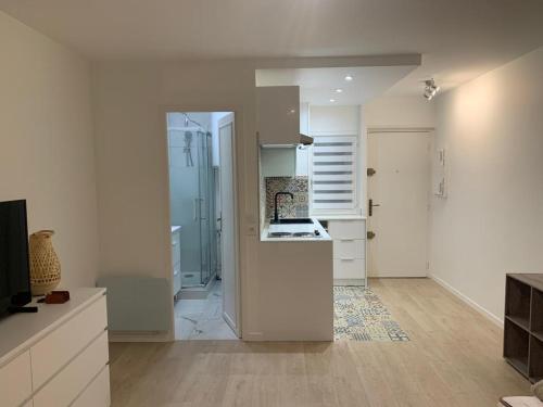 a kitchen with white cabinets and a stove top oven at Studio en hypercentre refait à neuf avec une belle terrasse! in Cabourg