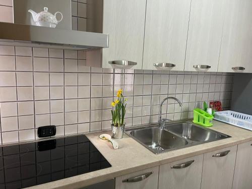 una cucina con lavello in acciaio inossidabile e piastrelle bianche di Marval a Monopoli