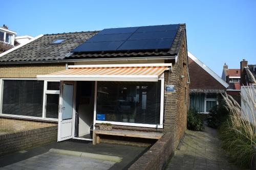 a house with solar panels on the roof at ZeeBedStay in Noordwijk aan Zee