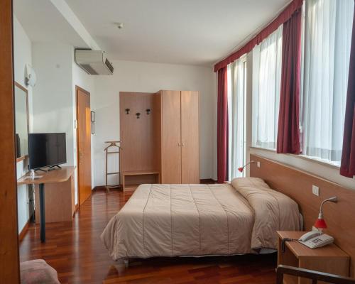 1 dormitorio con 1 cama y TV en Hotel all'Oasi en Paese