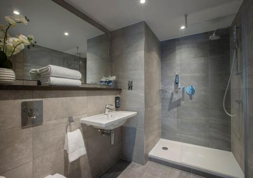 a bathroom with a sink and a shower at Clayton Hotel Chiswick in London