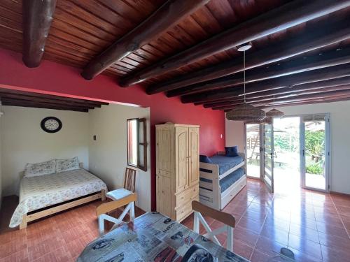1 dormitorio con paredes rojas, 1 cama y 1 mesa en Ayres de Cobo en Mar de Cobo
