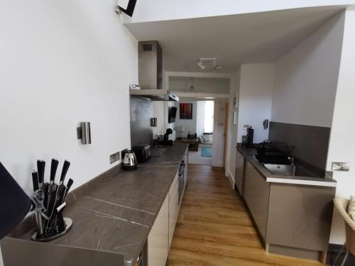 a kitchen with stainless steel countertops and a long counter top at Seashells at 2 TRENCROM COURT ST IVES in Carbis Bay