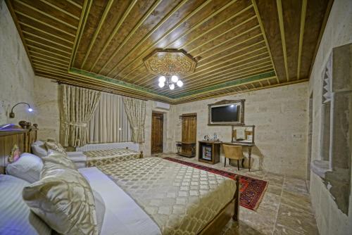 1 dormitorio con 2 camas, mesa y TV en Zultanite Cappadocia Hotel en Nevşehir