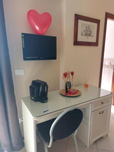 a desk with a heart hanging on a wall at Fiumicino Inn Airport in Fiumicino