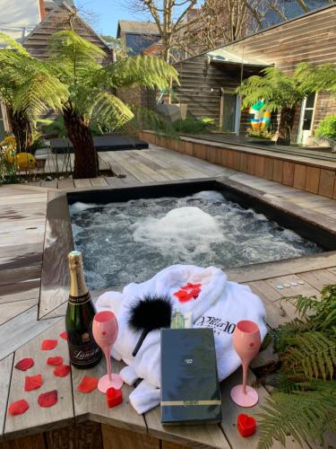 a hot tub with a bottle of champagne and a bottle of wine at La villa 10 HÔTEL SPA in Étretat