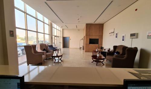 a waiting room with chairs and a table in a building at SPAR Furnished Hotel in Al Hofuf