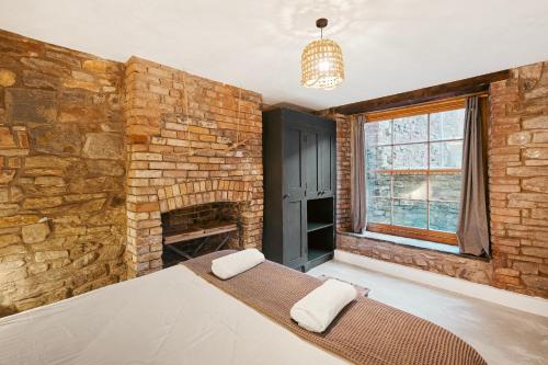 a bedroom with a brick wall and a bed in a room at Highbury Corner in Bristol