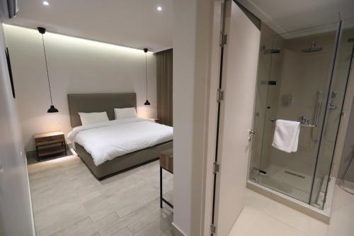 um quarto com uma cama e uma cabina de duche em vidro em Zerø Føur DeadSea em Sowayma