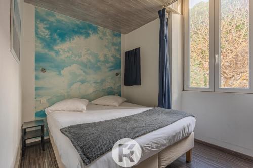 um quarto com uma cama com um quadro na parede em R'Apparts Le Petit Grenoblois - Gare em Grenoble