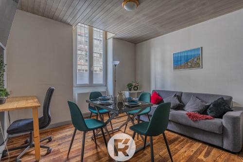 un salon avec un canapé, une table et des chaises dans l'établissement R'Apparts Le Petit Grenoblois - Gare, à Grenoble