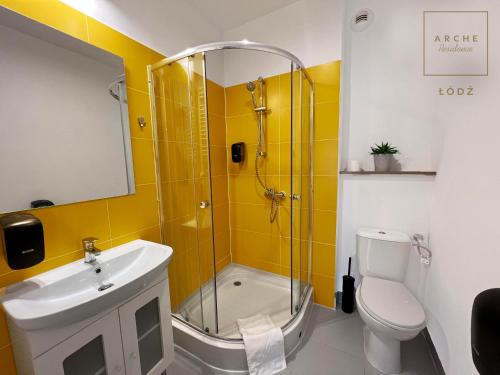 a bathroom with a shower and a sink and a toilet at Arche Residence Łódź in Łódź